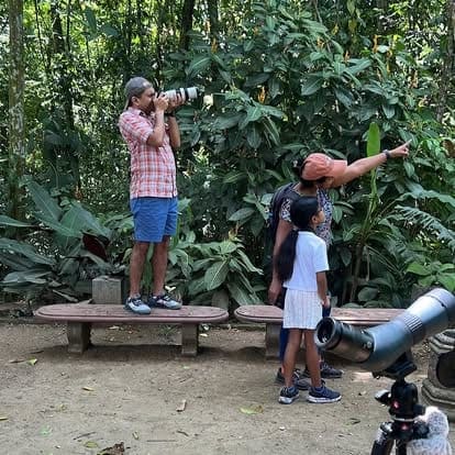 Family watching birds through a telescope alongside their VIVO guide
